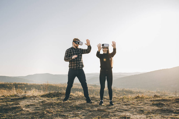 Innovation vr Technologie-Konzept, zwei Personen in Virtual-Reality-Box-Brille Gadget-Technologie auf der Straße im Wald auf Hügeln Natur Hintergrund, zwei Personen verwenden Headset digital für Entertainment-Erlebnis - Foto, Bild