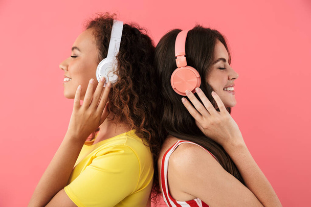Image of charming multinational girls listening to music with headphones - Φωτογραφία, εικόνα