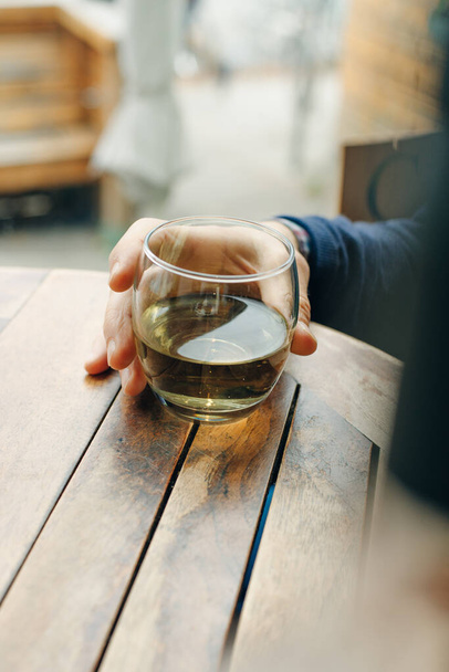 ヴィンテージ木製テーブルの上の白ワインのガラス - 写真・画像