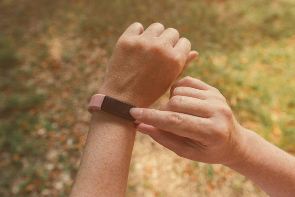 Female hiker with smart fitness tracker bracelet, close up - Фото, изображение