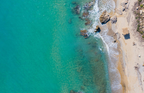 Aerial view of rocky seashore with blue water - Fotó, kép