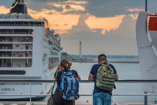 Couple enjoying sunset by the sea with cruise ships on background - Φωτογραφία, εικόνα