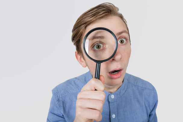 Curious Teenager with Magnifying Glass Isolated on the White Bac - Photo, Image
