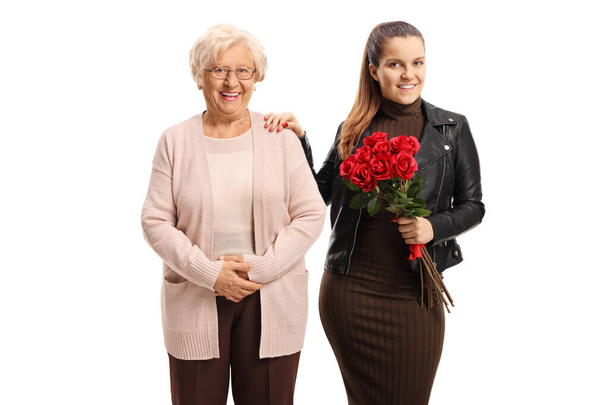 Enkelin hält einen Strauß Rosen und steht neben ihr  - Foto, Bild
