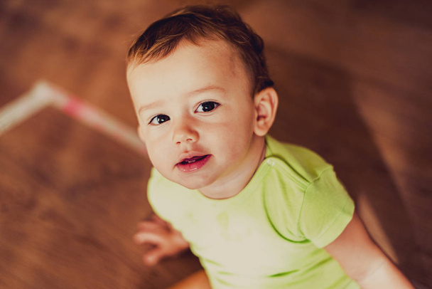 Πρόσωπο μωρού που φαίνεται από ψηλά κοιτάζοντας την κάμερα με attent - Φωτογραφία, εικόνα