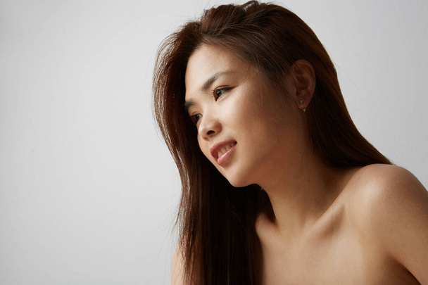 Side view of young Chinese woman posing on the white background. Isolated. - Foto, afbeelding