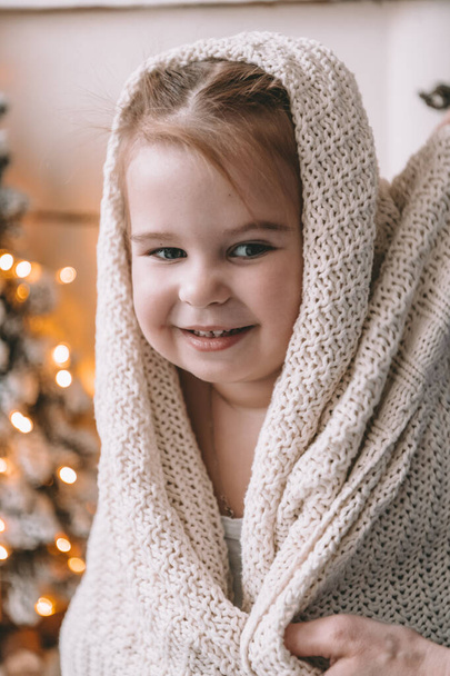 Little girl sitting on the bed wrapped in a blanket - Фото, зображення