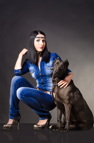 Beautiful young woman in jeans clothes sitting next to the dog - Fotografie, Obrázek
