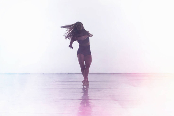 Молодой современный танцор танцует в студии. Спорт, танцы и ур - Фото, изображение