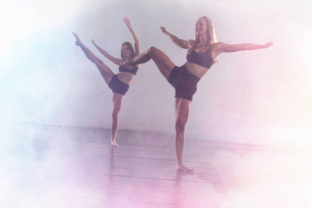Twee jonge moderne dansers dansen in de studio. Sport, dansen een - Foto, afbeelding