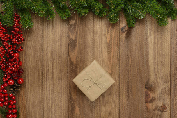 Gifts box on wooden background and green and red garland, top view - Foto, immagini