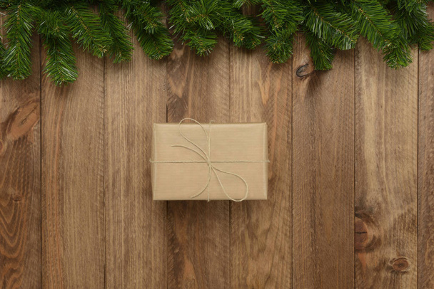 Gift box on wooden background and green garland, top view - Φωτογραφία, εικόνα