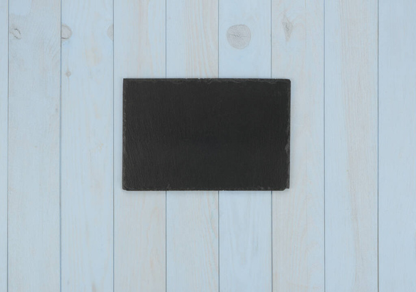 Kitchen items: black plate on blue wooden background - Φωτογραφία, εικόνα