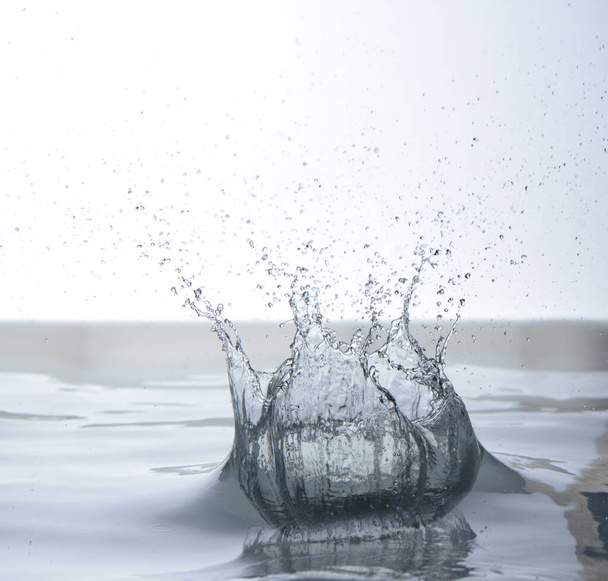 Agua en movimiento sobre fondo blanco, chorros y gotas
 - Foto, imagen