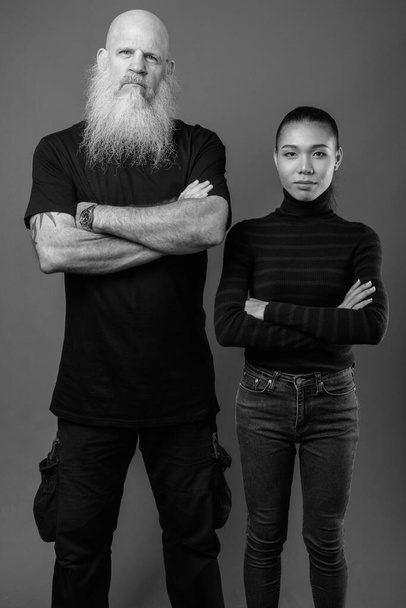 Dojrzałe brodaty łysy mężczyzna z młody Azji transgender kobieta razem w czarny i biały - Zdjęcie, obraz