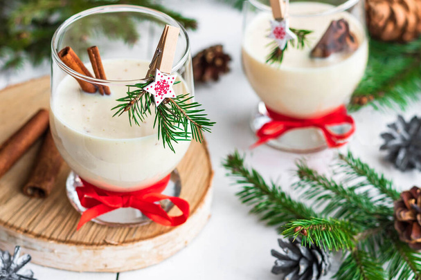 Traditional eggnog Christmas cocktail in a glass goblet decorated with New Year clothespin. Non-alcoholic option. - Foto, Imagen