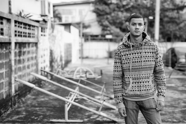 junger multiethnischer asiatischer Mann im Freien in schwarz und weiß - Foto, Bild