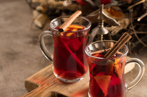 Two glasses of christmas mulled wine with oranges and spices on a textural background. Selective focus. Copy space. - Фото, зображення