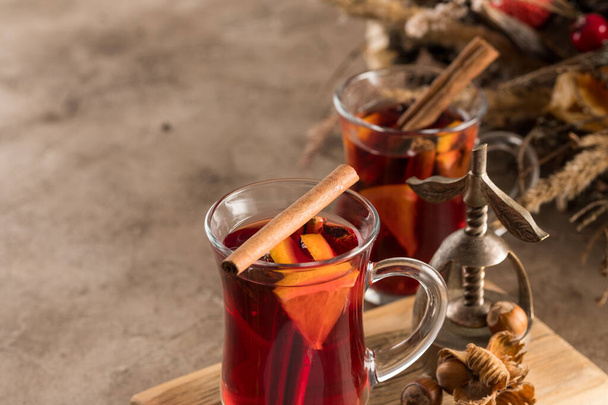 Two glasses of christmas mulled wine with oranges and spices on a textural background. Selective focus. Copy space. - Valokuva, kuva