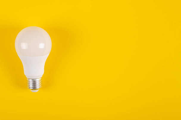 LED light bulb composition on yellow background. - Фото, изображение