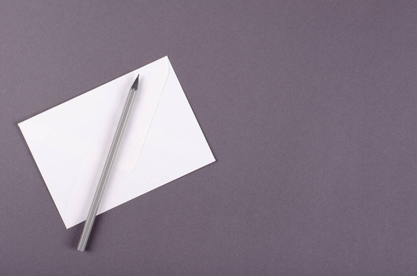 Paper envelope with pencil composition on dark background. - Fotó, kép