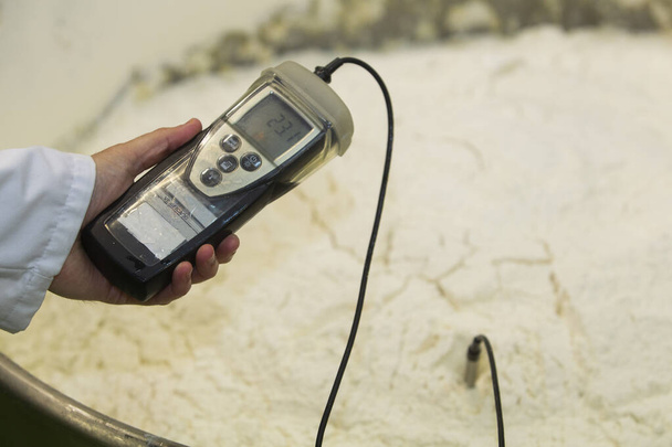 worker measuring the temperature of the raw dough - Foto, imagen