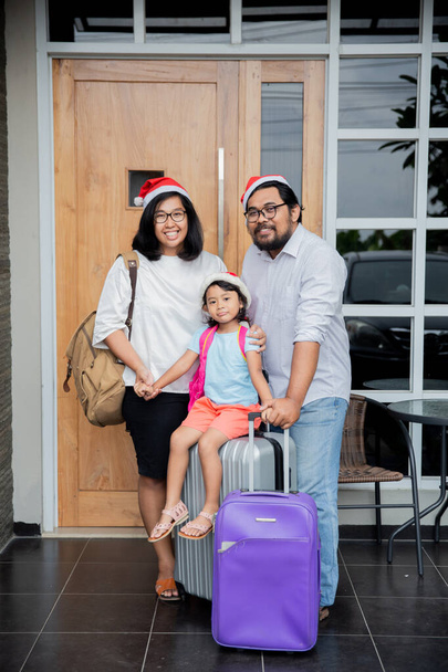 family with suitcase walking in front of their house - Foto, Bild