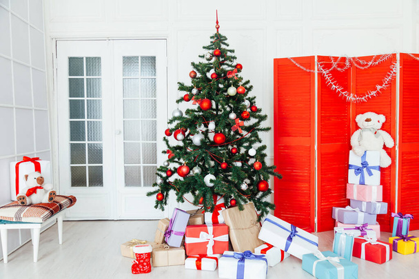 Interior de la habitación blanca de Navidad con regalos rojos para el nuevo año
 - Foto, Imagen