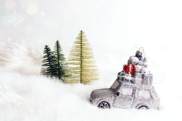 Toy car with gifts and fir trees on white fur background that lo - Photo, Image