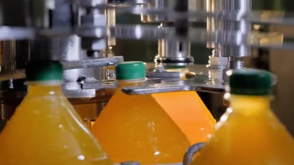Meyve suyu üretiminde plastik şişelerdeki otomatik taşıma hattının kapaklarını kapat. - Video, Çekim