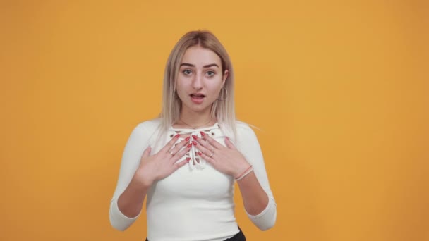 Young blonde woman with surprise facial expression, keeping hands on cheeks - Filmmaterial, Video