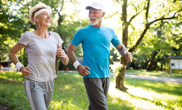 Beautiful senior couple jogging in nature living healthy - Photo, Image