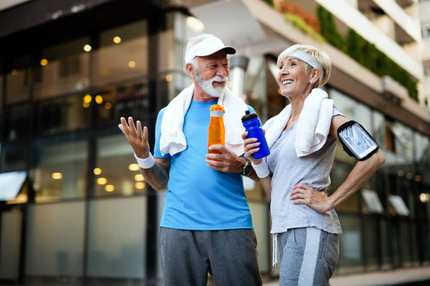 Healthy senior couple jogging in the city at early morning - Photo, Image