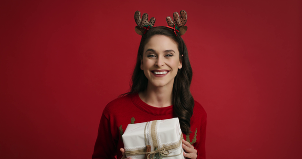 Woman with Christmas present on red background  - Video