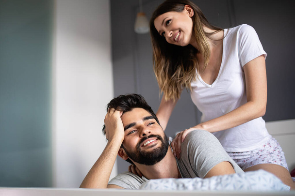 Young happy couple making massage in bedroom - Foto, Bild