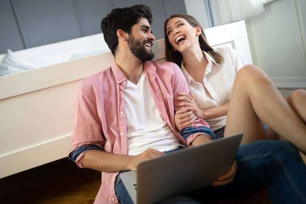 Young couple relaxing on bed with laptop. Love, happiness, technology, people and fun concept. - Φωτογραφία, εικόνα