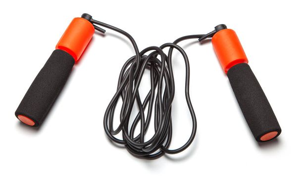 ジャンプ・ロープ。体の健康のための楽しい演習。黒いコードのオレンジロープ。白地に隔離された - 写真・画像