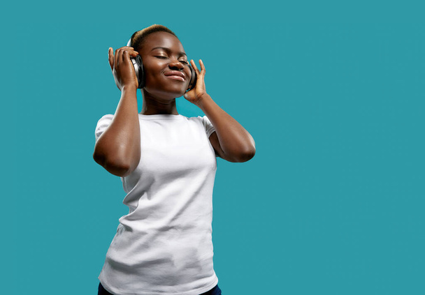 Relaxed female in bluetooth headphones listening music - Фото, зображення