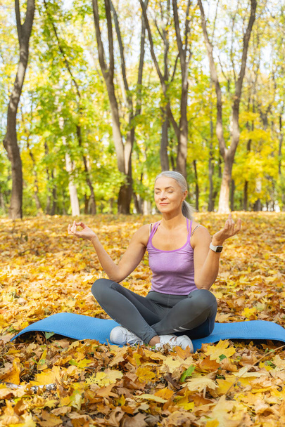 Woman with closed eyes doing yoga outdoors - Zdjęcie, obraz