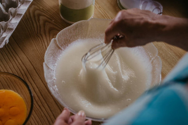 ενήλικη γυναίκα στην κουζίνα ζυμώνει το μείγμα για γλυκά και επιδόρπια - Φωτογραφία, εικόνα