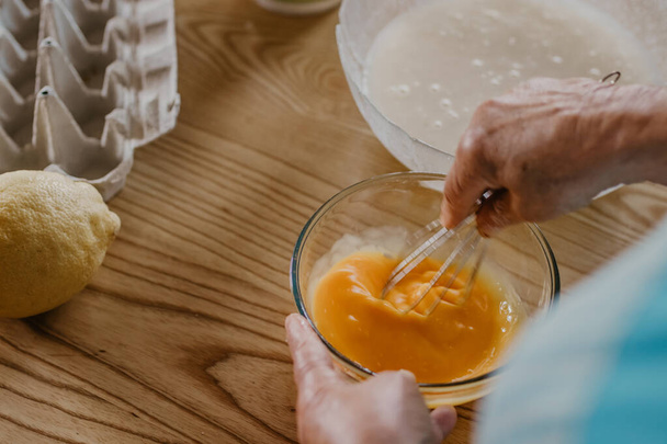cocine mezclando y batiendo huevos e ingredientes para dulces y pasteles
 - Foto, Imagen