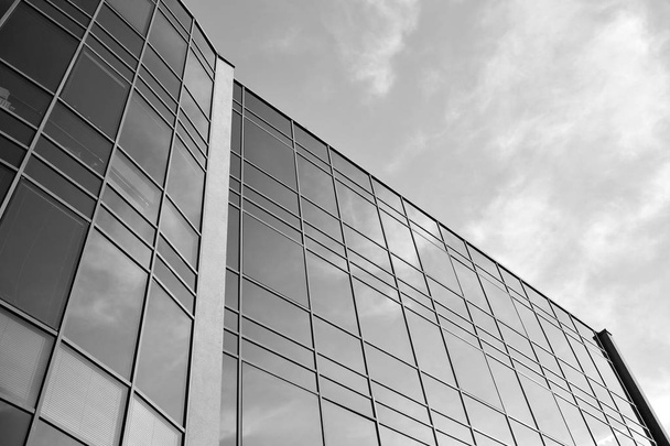 Gökyüzünün altındaki tonlu cam ve çelik yapılardan oluşan perde. Binanın bir parçası. Siyah ve beyaz. - Fotoğraf, Görsel