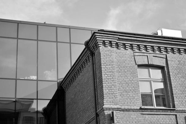 Mur rideau en verre tonique et des constructions en acier sous le ciel. Un fragment de bâtiment. Noir et blanc
. - Photo, image