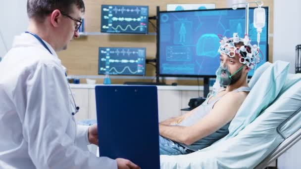 Pacjent w centrum neurologicznym w falach mózgowych skanujący słuchawki i maskę powietrzną - Materiał filmowy, wideo