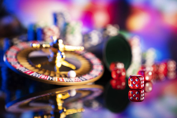 Τα τυχερά παιχνίδια θέμα. Ζάρια, ρουλέτα η ρόδα και το πόκερ μάρκες σε χρώμα φόντου bokeh. - Φωτογραφία, εικόνα