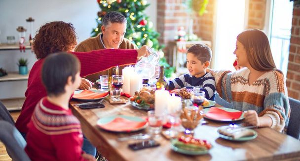 Gyönyörű család mosolyogva boldog és magabiztos. Pörkölt pulykát eszünk, otthon ünnepeljük a karácsonyt - Fotó, kép