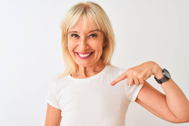 Middle age woman wearing casual t-shirt standing over isolated white background with surprise face pointing finger to himself - Zdjęcie, obraz