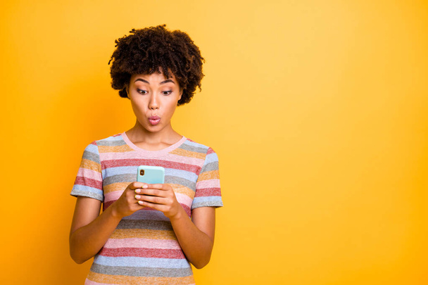 Photo of wavy charming sweet cute girl having received unexpected feedback in her social media pouting her lips holding telephone isolated over yellow vivid color background - Foto, afbeelding