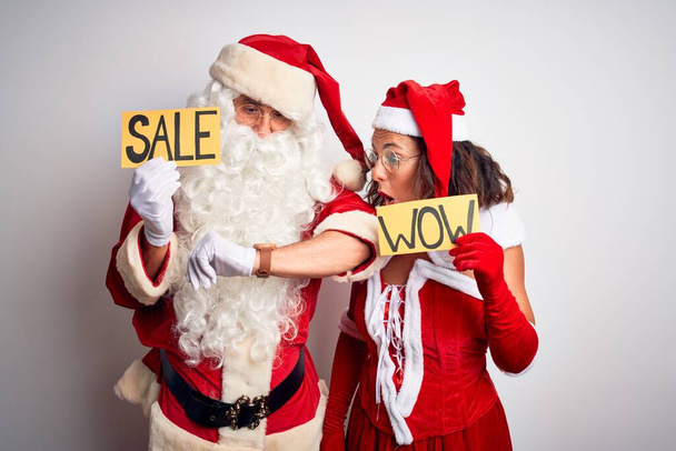 Pari yllään Santa puku tilalla wow ja myynti banneri yli eristetty valkoinen tausta Katsella kellon aika huolissaan, pelkää saada myöhään
 - Valokuva, kuva