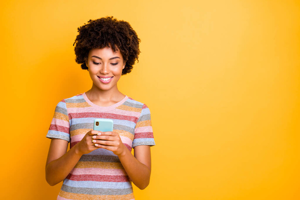 Photo of cheerful cute charming positive girlfriend browsing through her telephone searching for new infromation about blogging isolated over vivid yellow color background - Fotoğraf, Görsel